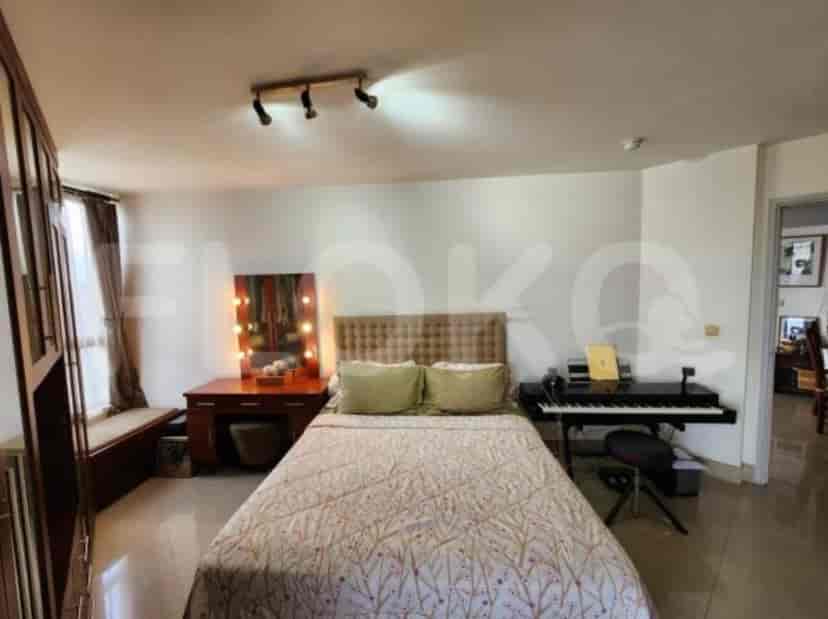 A bedroom with a bed, dresser, and piano.