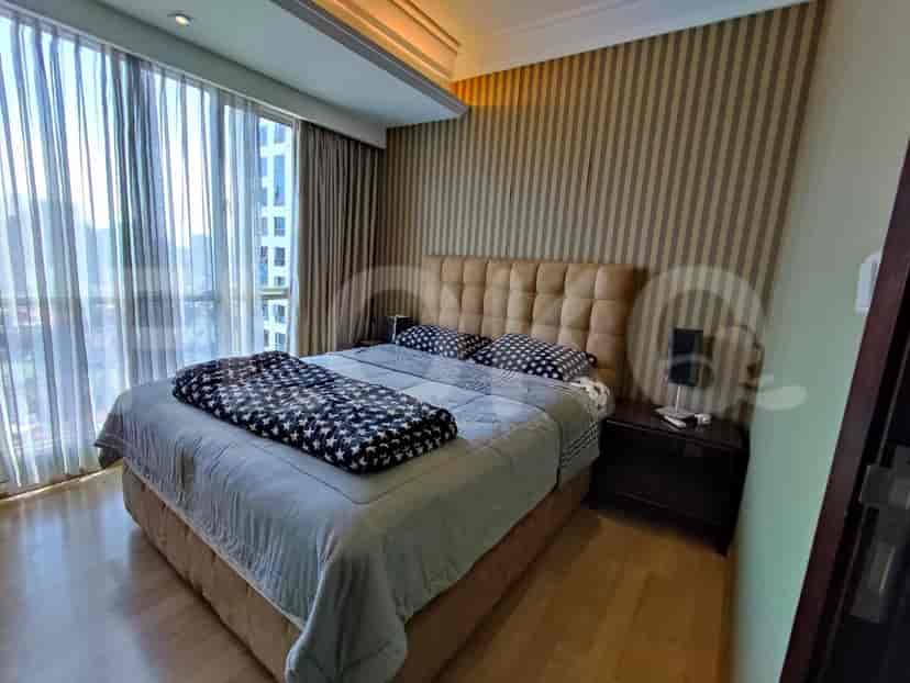 Guest bedroom with a queen bed and striped wallpaper.
