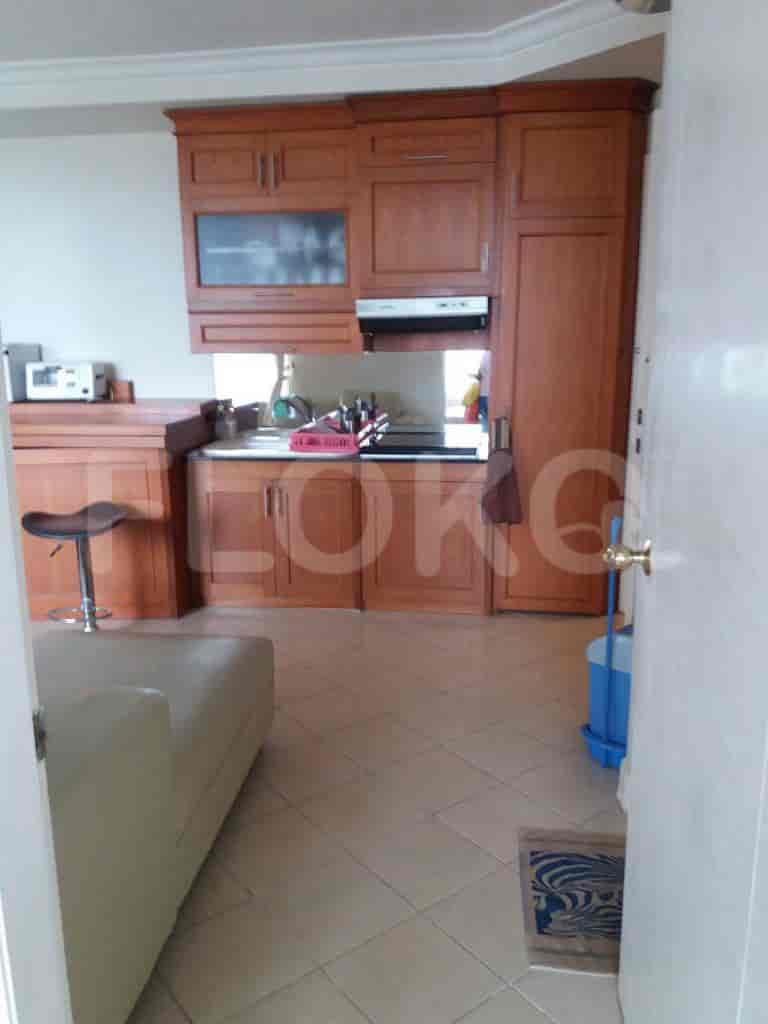Kitchen with wooden cabinets, a sink, and a view towards the living area.