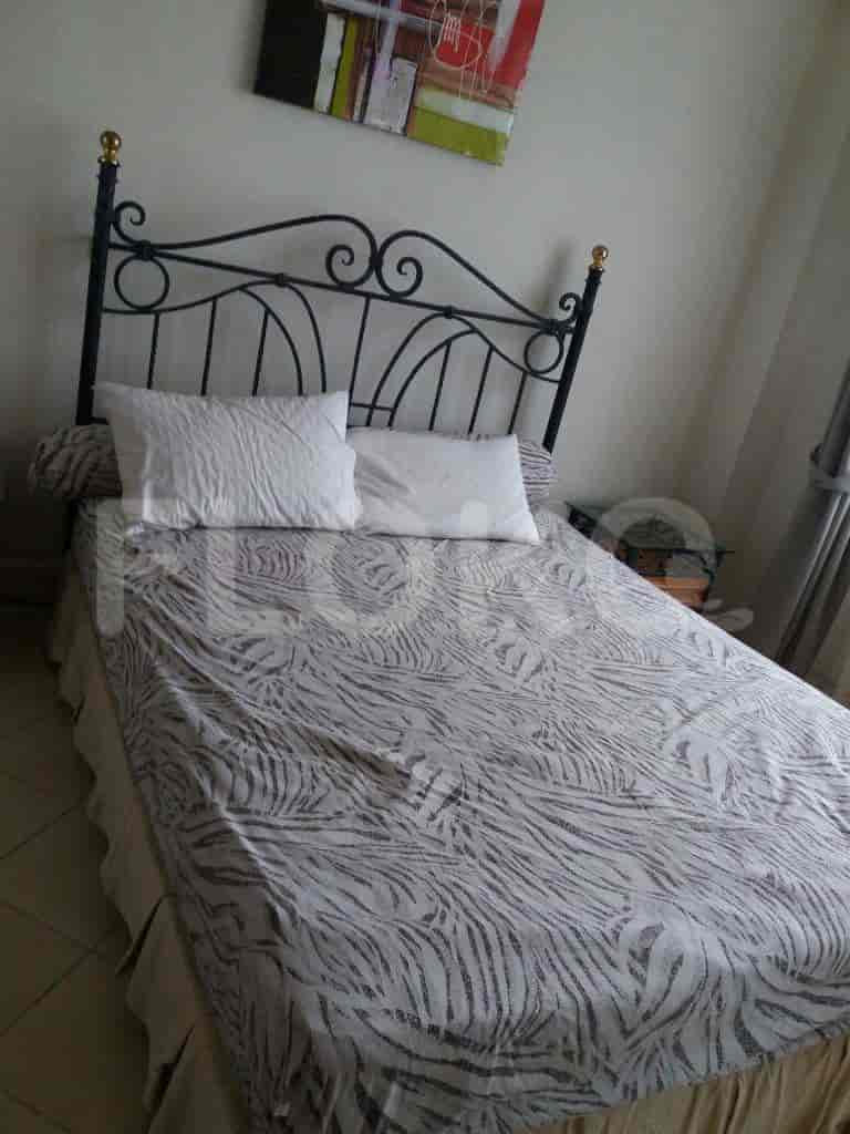 Bedroom with a bed featuring a patterned comforter and a wrought iron headboard.