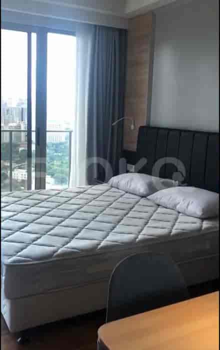 A bedroom with a bed, balcony access, and city views.