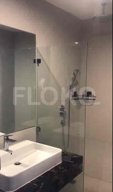A modern bathroom with a glass shower and sink.