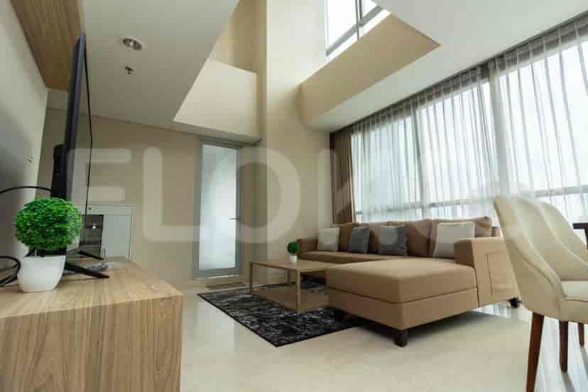 Living room with sofa, TV, and door to balcony.