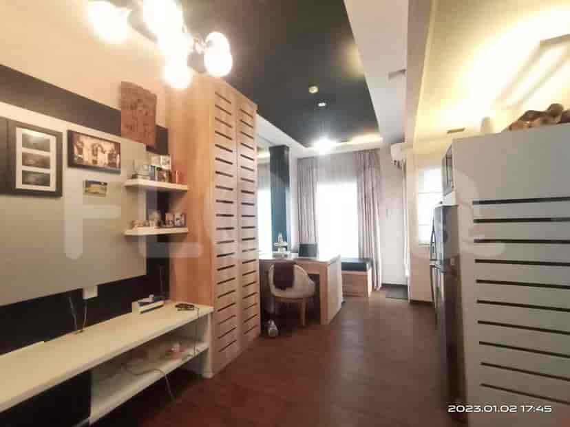 Living space with built-in wooden storage, desk, and kitchen area visible.