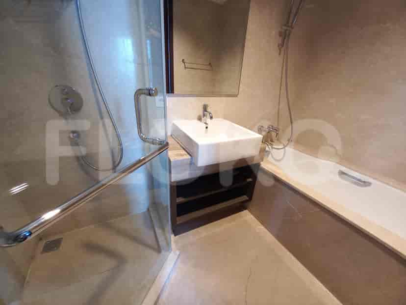 Kamar mandi modern dengan pancuran berkaca, bak mandi, dan finishing marmer.