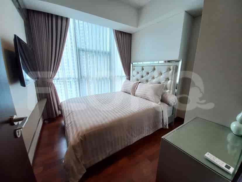 Kamar tidur mewah dengan tempat tidur dengan kepala tempat tidur cermin, dan jendela besar.