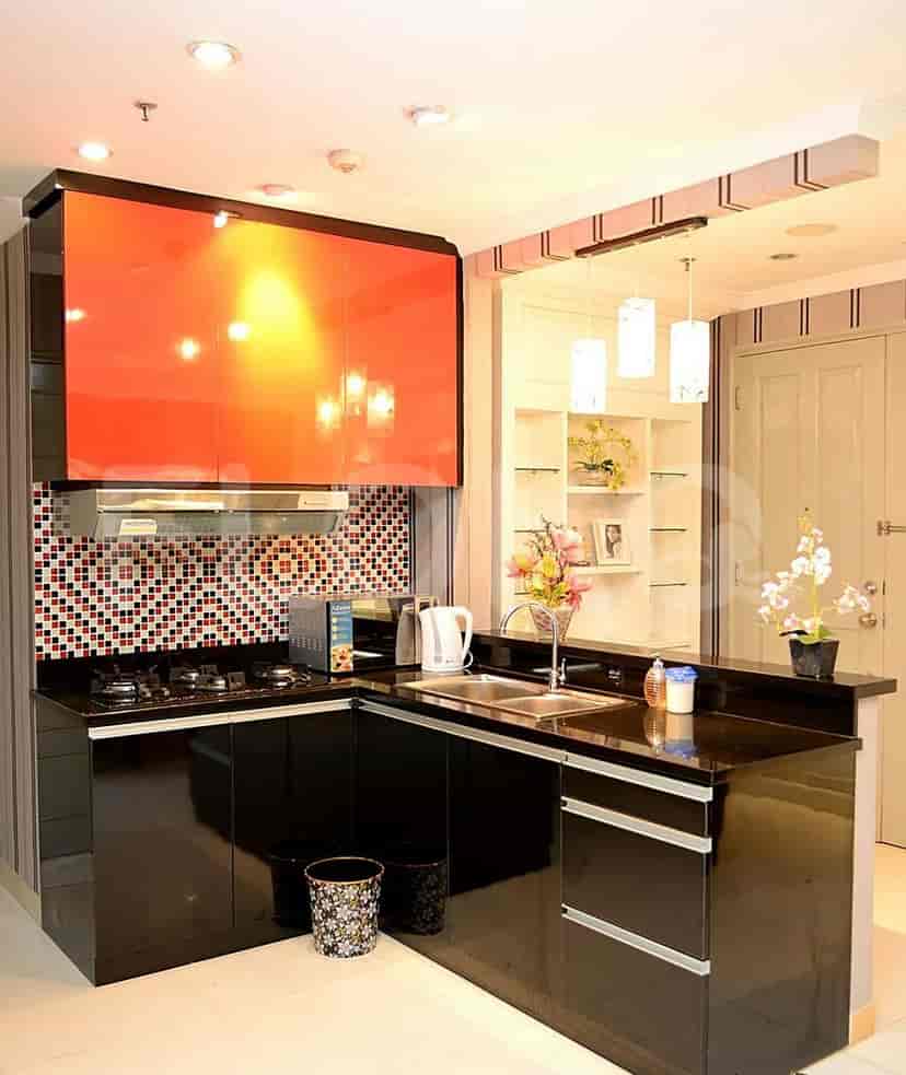 Kitchen with red cabinets and black countertops.