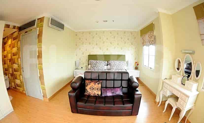 Bedroom with bed and small sofa.