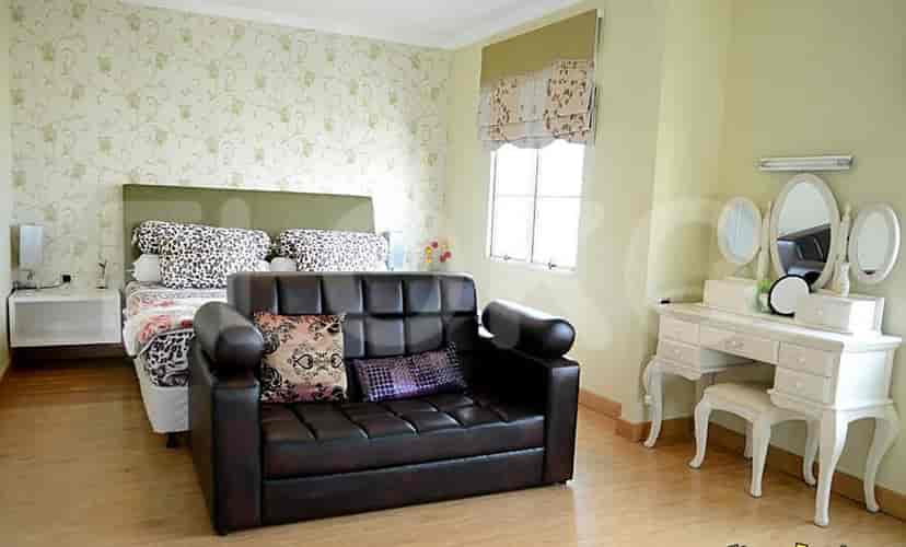 Bedroom with bed and small sofa.