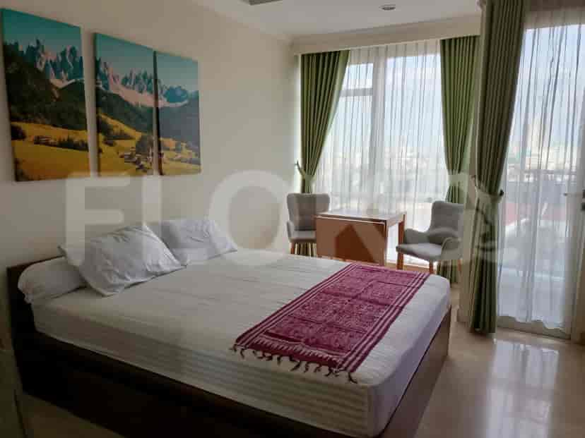 Kamar tidur dengan tempat tidur, jendela besar, dan seni dekoratif.