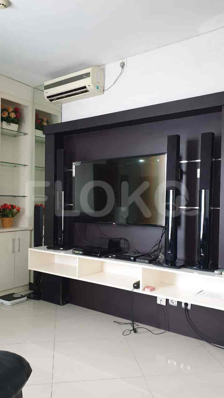 Living room with a large TV on a feature wall, black speakers and white cabinets
