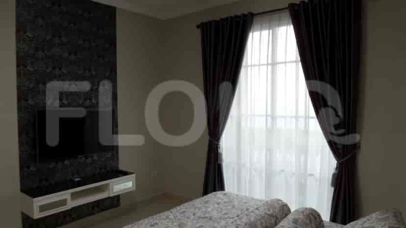 Bedroom with a TV mounted on the wall, curtains, and a decorative bed.