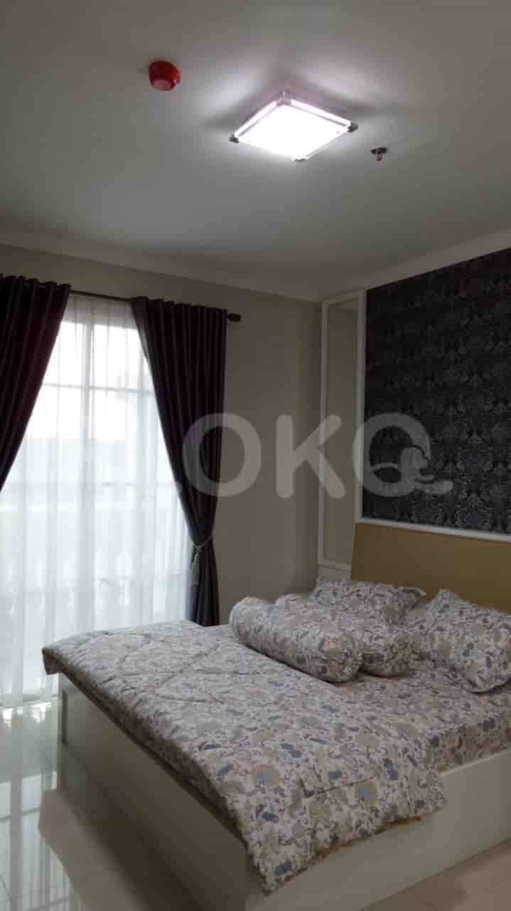 Bedroom with large window, curtains, and a decorative bed.