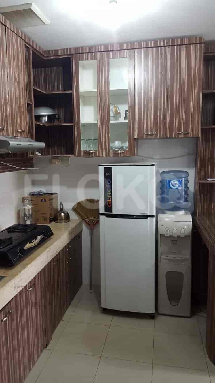 A modern kitchen with wooden cabinets, a refrigerator, and a gas stove.