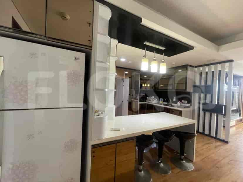 A modern kitchen with an island, appliances, and bar stools.