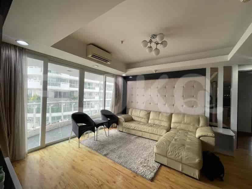 A living room with a sectional sofa, large windows, and a modern design.