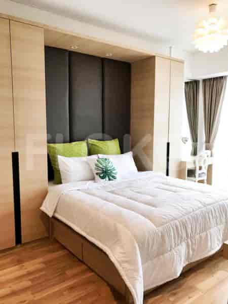 Kamar tidur modern dengan tempat tidur berukuran queen, lemari pakaian built-in, dan bantal dekoratif.