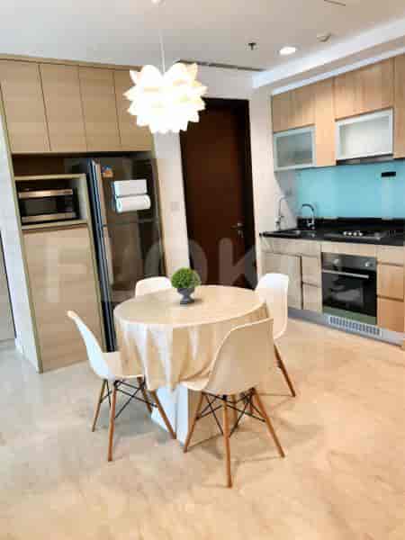 Dapur dan area makan yang bergaya dengan peralatan modern, kursi putih, dan meja makan bundar.