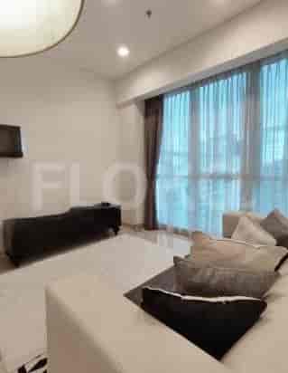 A modern living room with a sofa, curtains, and a TV mounted on the wall.