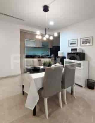 A dining area with a table, chairs, and a kitchen in the background.