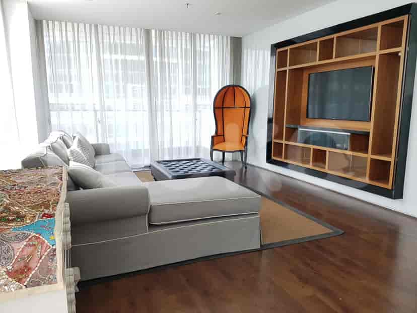 Living room with sofa, accent chair, and wall-mounted TV.