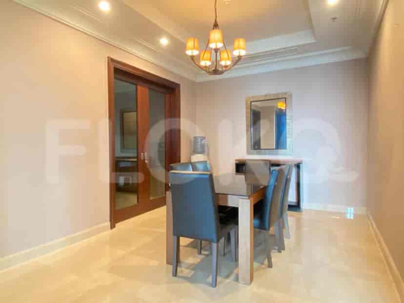 The dining room with a table, chairs, and a chandelier.