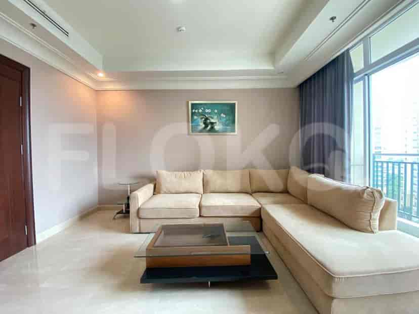 Another view of the living room, showing the sofa, coffee table, and artwork.