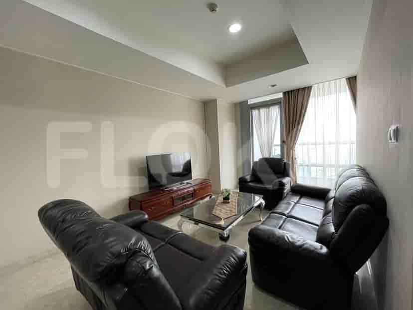 A living room with black leather sofas, a TV, and a coffee table.