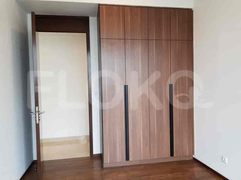 A bedroom closet with wooden doors.