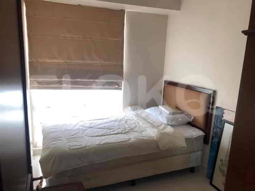 Small bedroom with a bed and a window with shade.