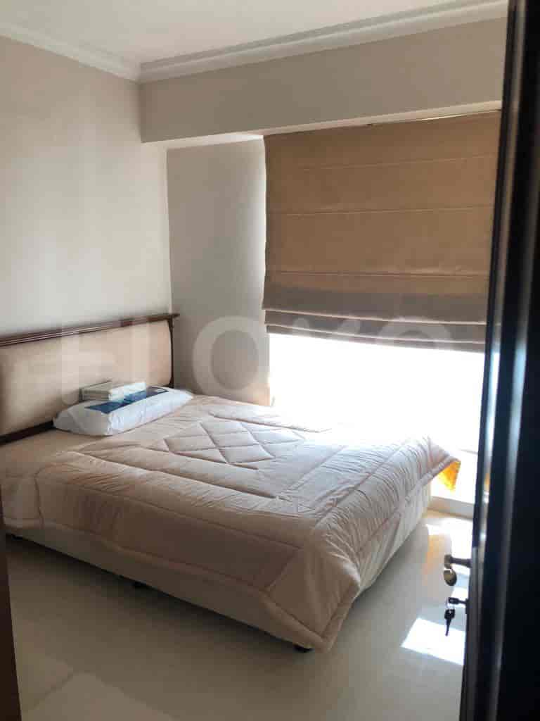 Bedroom with a large bed, window, and a Roman shade.