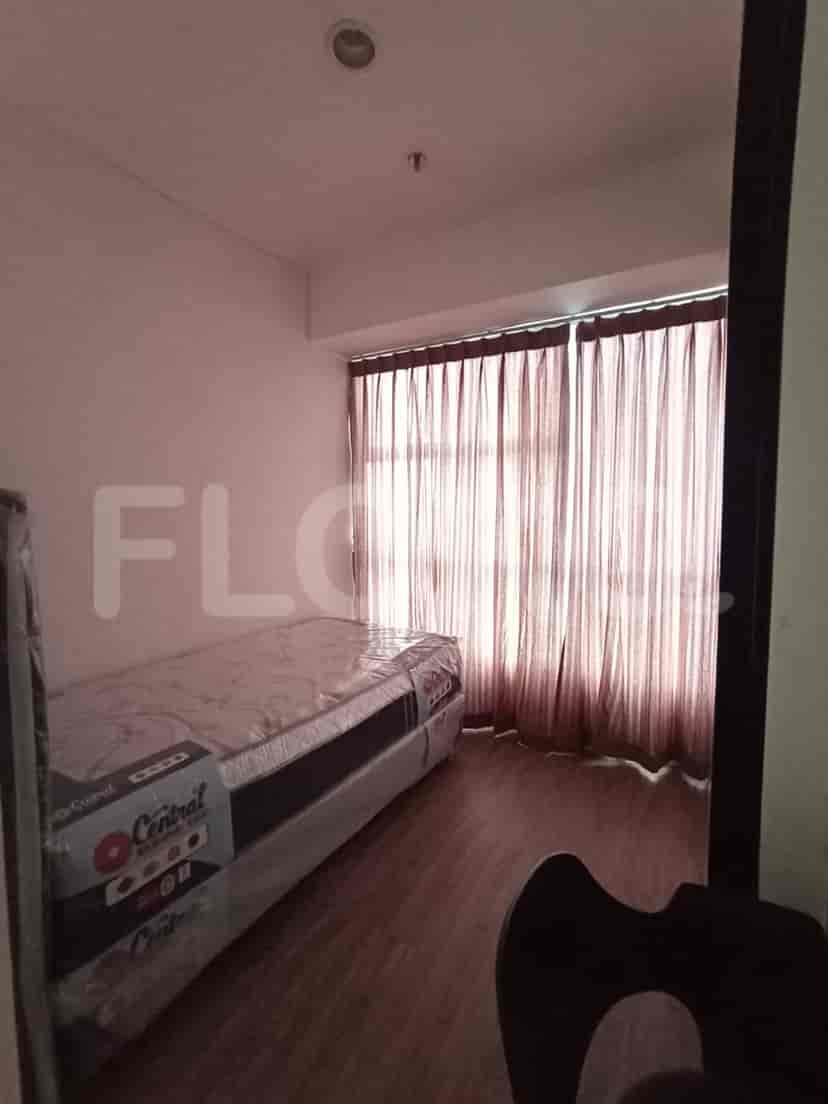 A bedroom with a single bed and curtains.