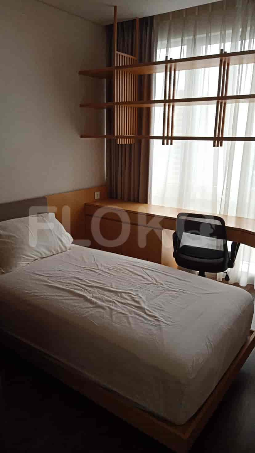 A minimalist bedroom with a single bed and a study desk.