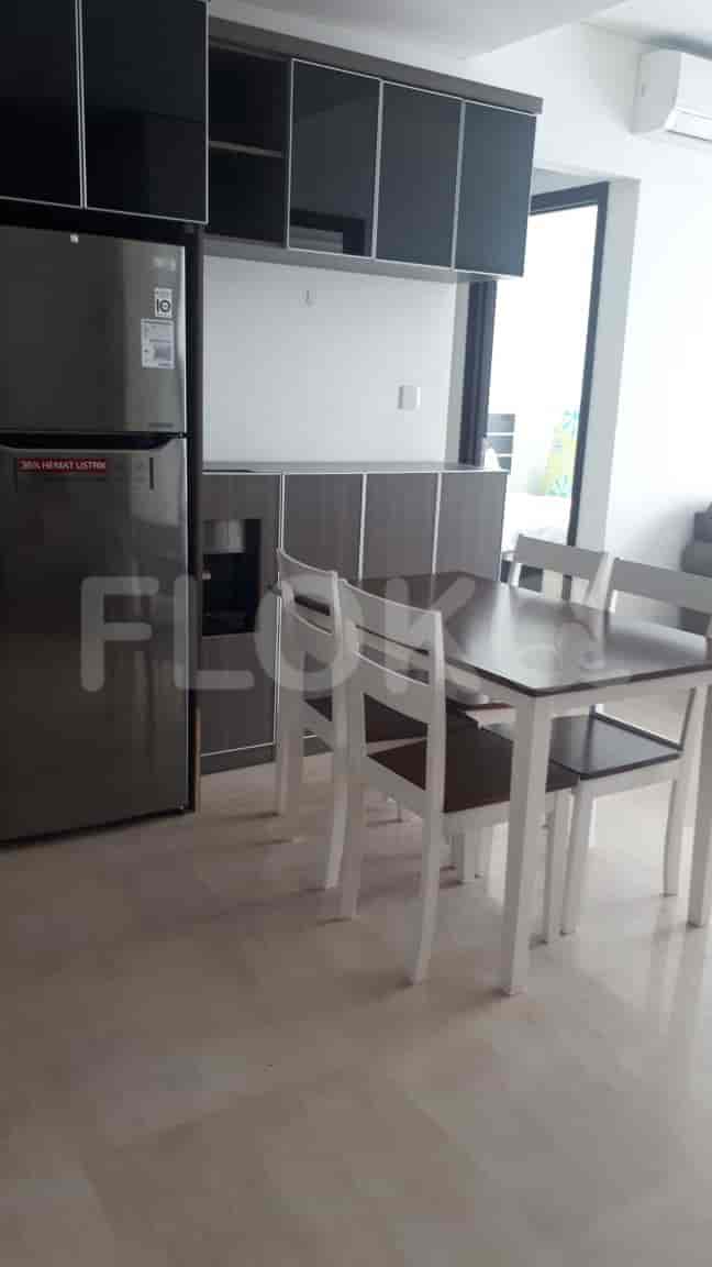 Kitchen and dining area with a refrigerator, cabinets, and dining table.