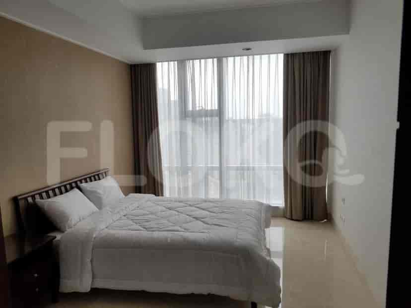 A bedroom with a queen-sized bed, large window, and neutral-toned walls.