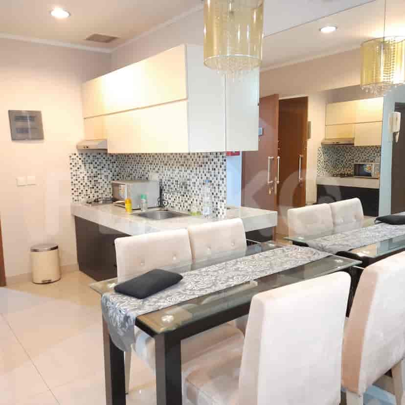 A modern kitchen open to a dining area, with a central island and a dining table with chairs.