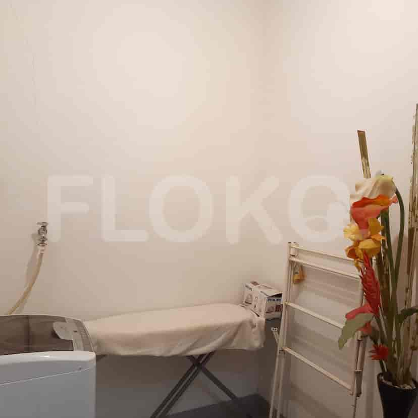A functional utility room with an ironing board, washing machine, and drying rack.