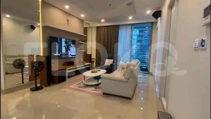 Modern living room with a smart TV, light-colored sofas, and a balcony view.