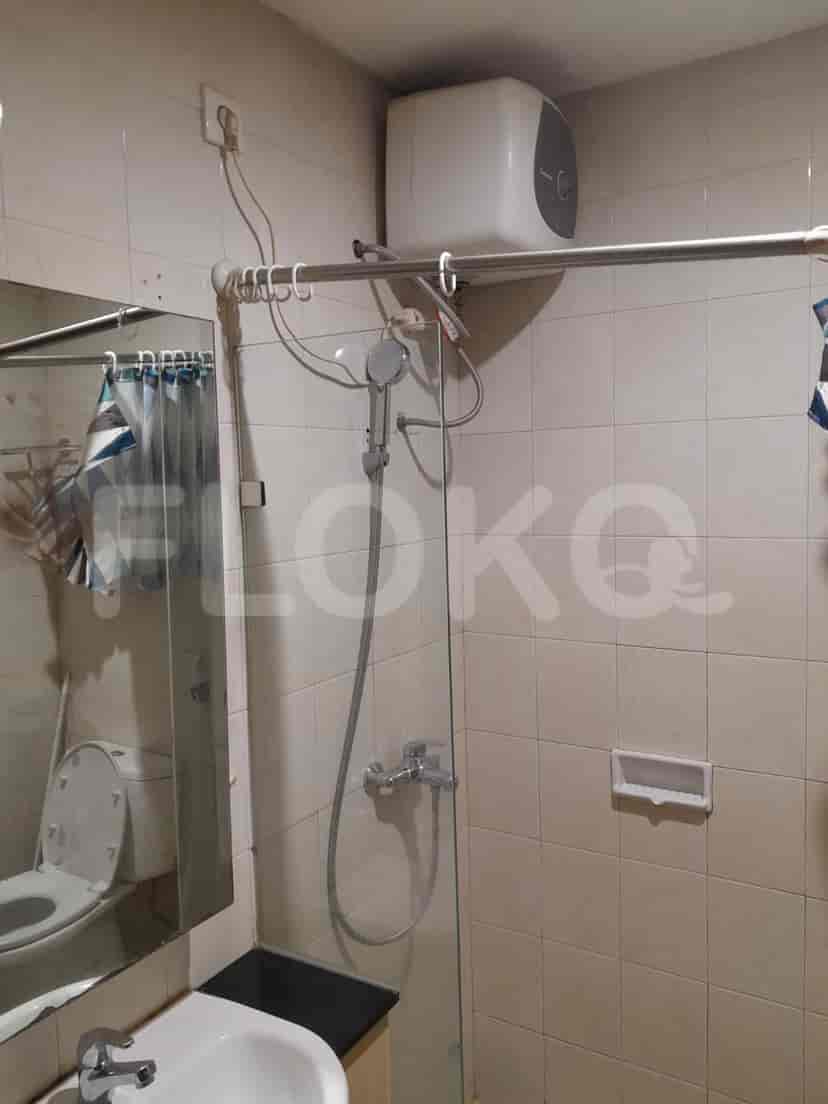 A simple bathroom with a shower, mirror, and toilet.