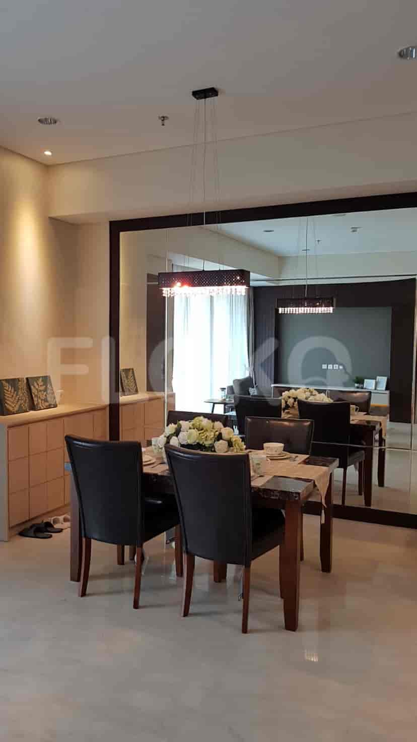 A dining room with a dining set, mirror, and neutral color scheme.