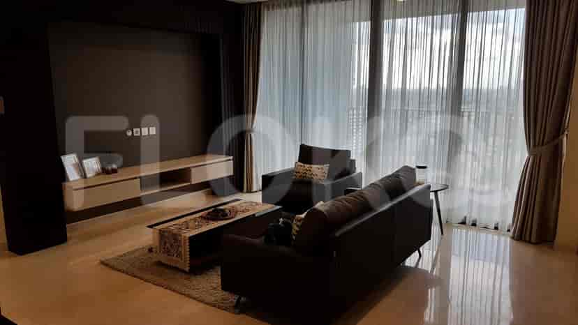 A modern living room with dark grey sofas, coffee table, and a wall-mounted entertainment unit.