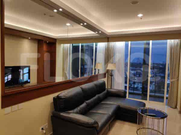 Modern living room with a black leather sectional sofa, TV, and city view.