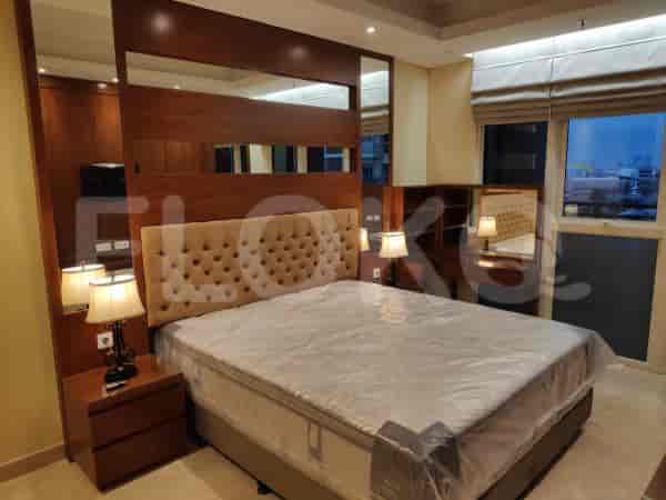 Bedroom with a large bed, mirror, and lamps.