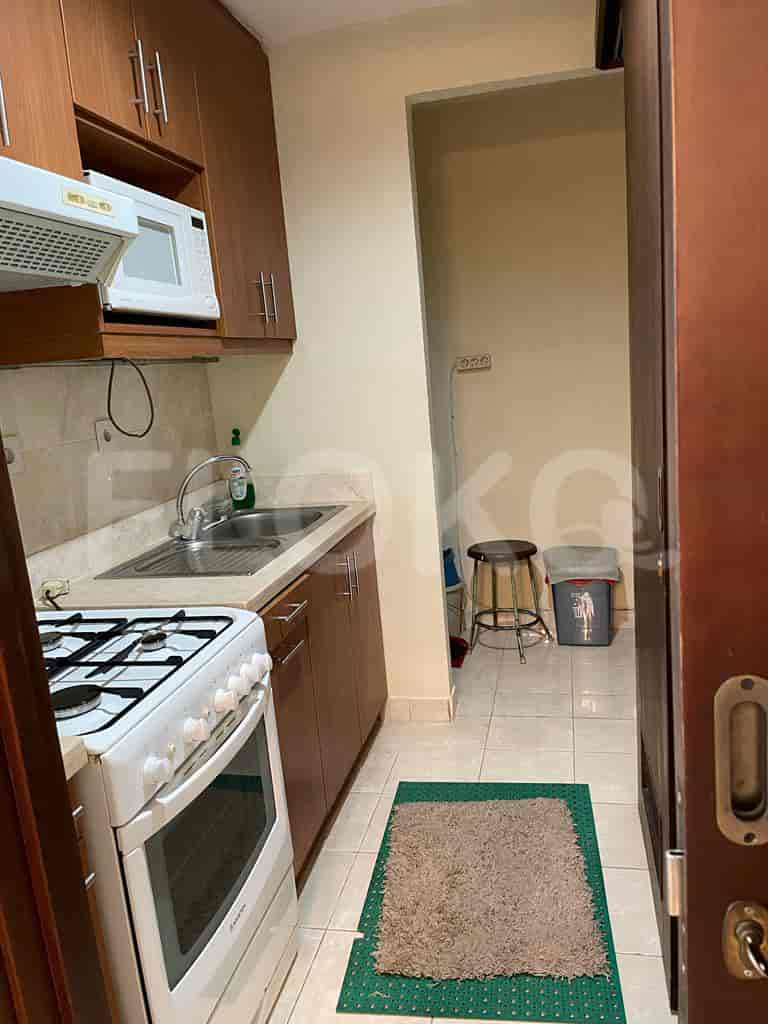 Small kitchen with a gas stove, sink, and overhead cabinets.