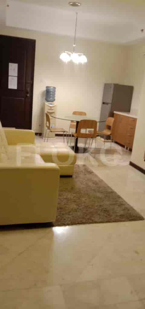 Open plan living and dining area with a sofa, rug, and dining table.
