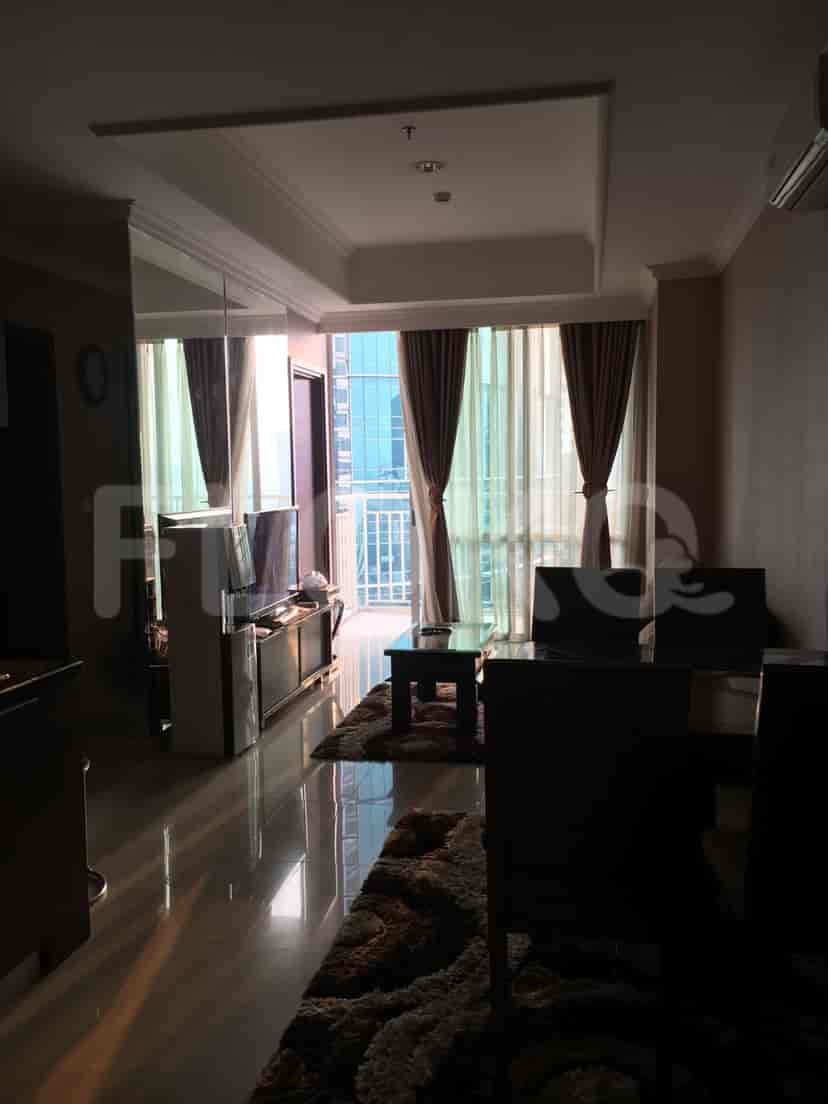 A living room with a large window, seating area, and dining table.