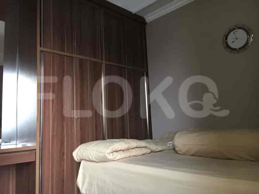 A bedroom with a bed, wardrobe, and a clock on the wall.