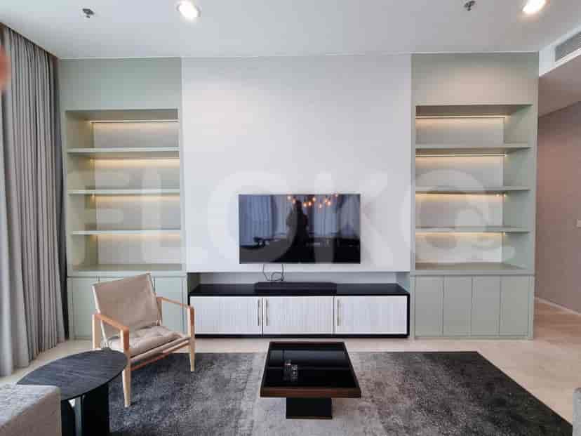 Living room with built-in shelving, TV, and a modern aesthetic.