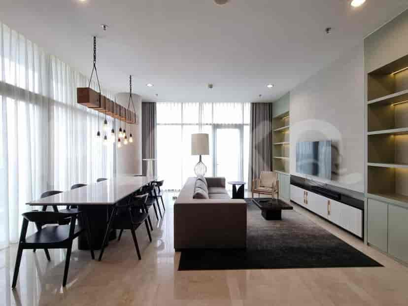 Spacious living area featuring a dining table, sofa, and open kitchen layout.