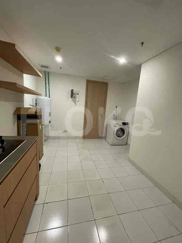 A small room with a washing machine, dryer, and storage.